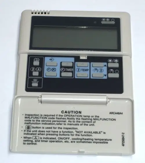 Daikin Fernbedienung mit mehreren Tasten für Temperaturregelung, Timer und Betriebsmodi. Hinweistexte zur Funktionsprüfung auf der Rückseite.